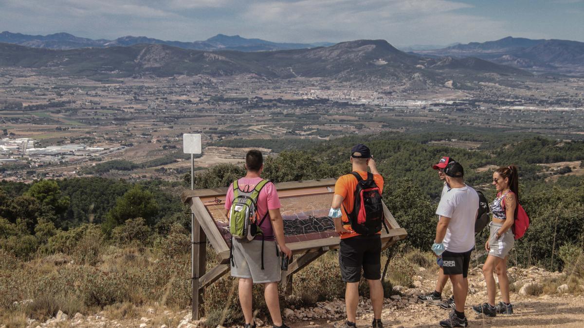Visitantes en el parque natural de la Font Roja contemplando la vertiente solana del espacio natural, que recae hacia Ibi.