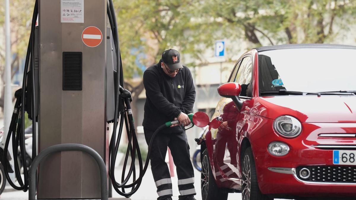 Un hombre repostando en una gasolinera.