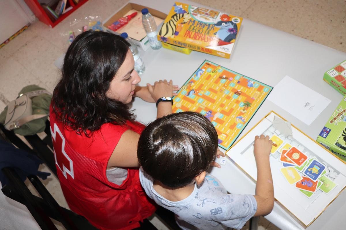 Una voluntaria de Cruz Roja juega con un niño.