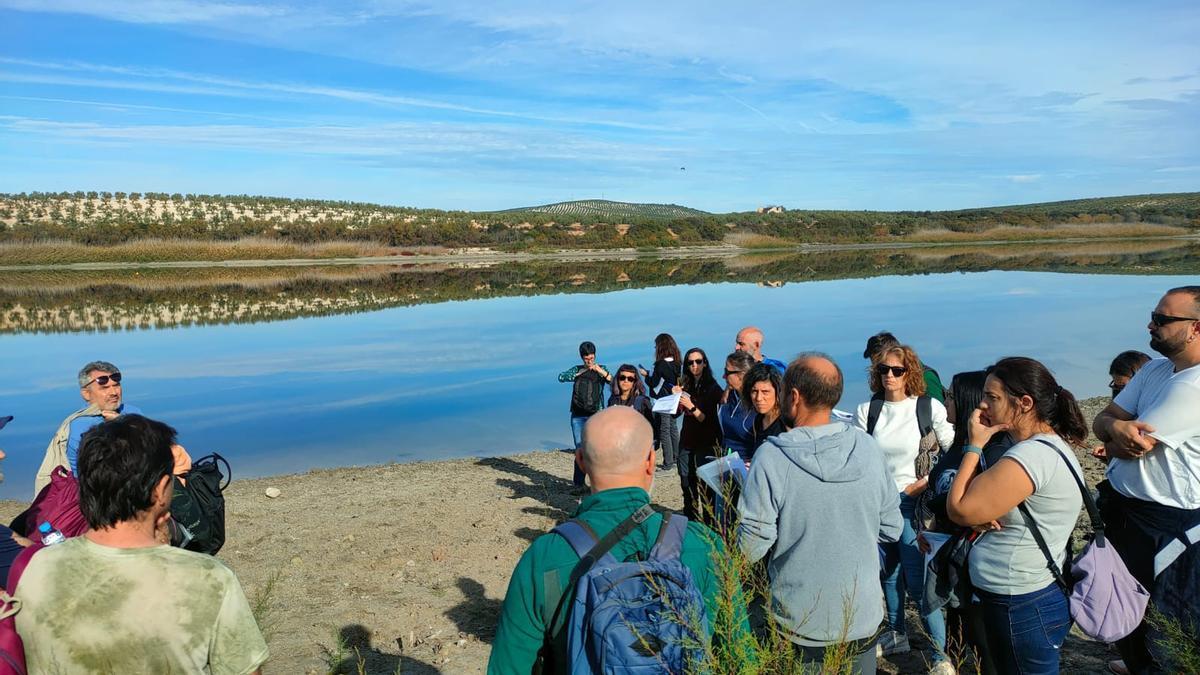 Unos visitantes atienden a explicaciones en la Laguna de Zóñar.
