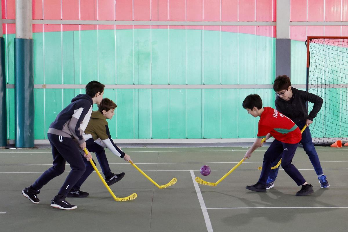 Alumnos jugando al hóckey durante su recreo en el colegio vigués Balaídos.