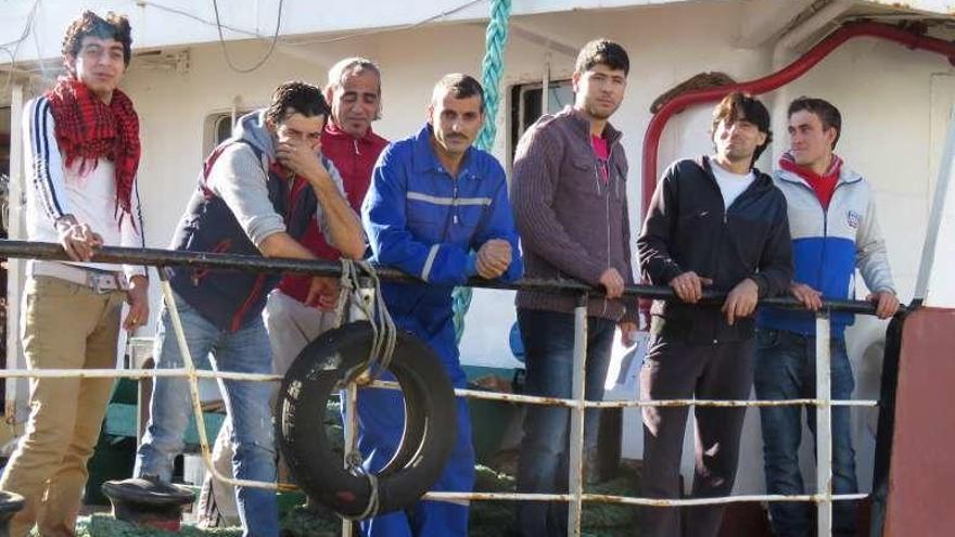 Siete sirios solicitantes de asilo, ayer, en el puerto de Marín.