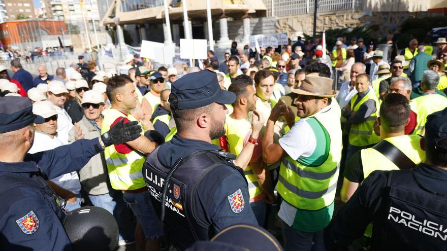 Agentes de policía tratan de
que los agricultores dejen
de cortar la vía.  IVÁN J.URQUÍZAR