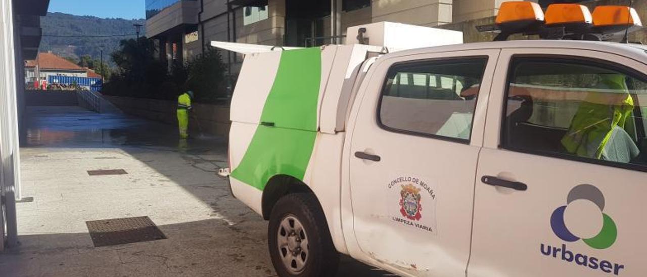 Trabajadora de la limpieza viaria, esta semana, chorreando la calle “Arturo Garrido” en el barrio de O Rosal.   | GONZALO NÚÑEZ