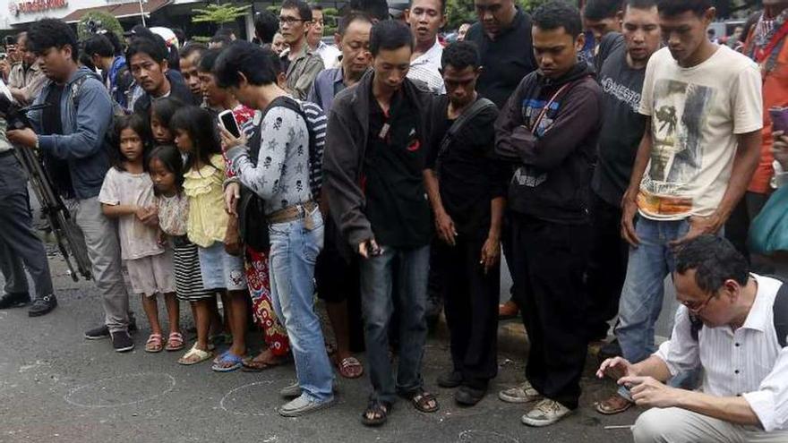 Curiosos observan un charco de sangre tras los ataques en Yakarta. // Efe