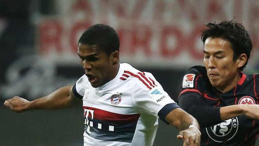 Douglas Costa y Hasebe pelean por el balón, ayer en Frankfurt.