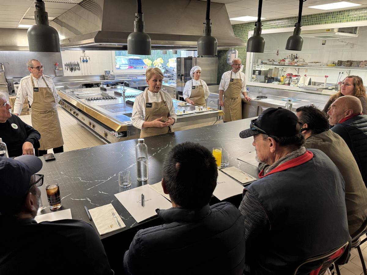 La chef Susi Díaz explica a personas atendidas en Cáritas alguna de las recetas