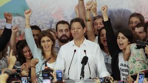 Flanked by his wife Ana Estela  left  and running mate Manuela d Avila  Workers  Party presidential candidate Fernando Haddad pauses during his concession speech while his staff and supporters cheer him on  in Sao Paulo  Brazil. Supreme Electoral Tribunal declared far-right congressman Jair Bolsonaro the next president of Latin Americaa  s biggest country   AP Photo Andre Penner 