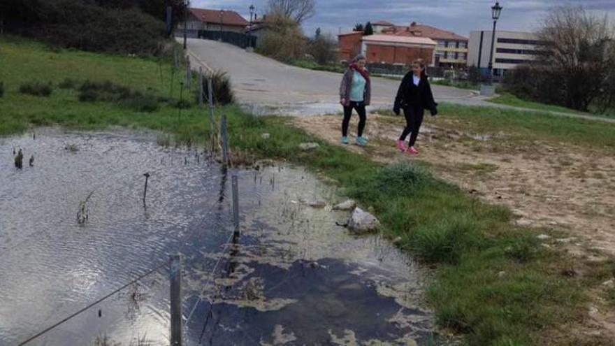 Dos mujeres que se dirigen a la pista finlandesa pasan junto a una zona inundada.