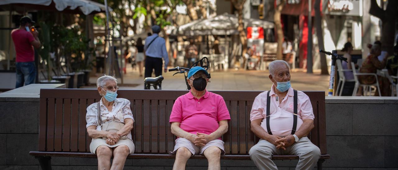 Tres personas permanecen sentadas portando sus mascarillas en la capital chicharrera.