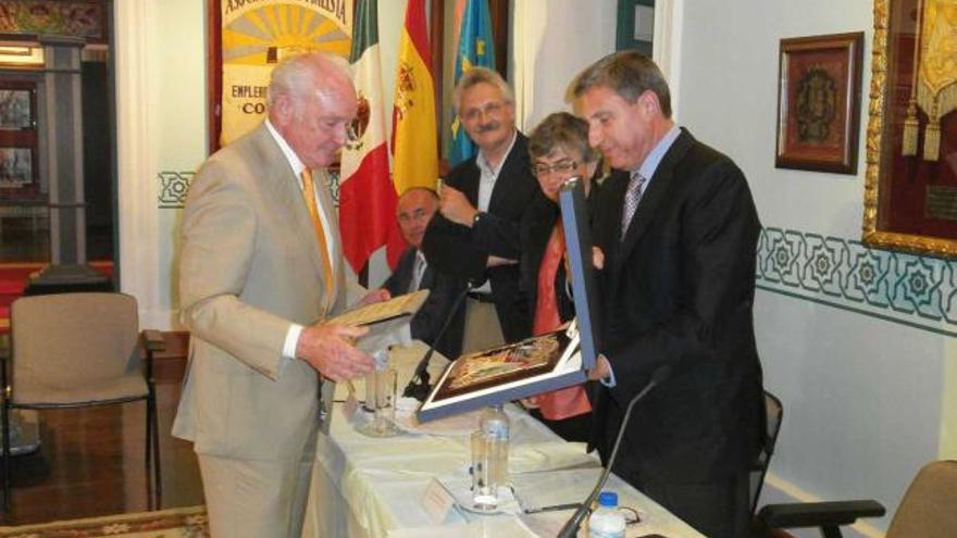 Segura -izquierda- recibe una placa conmemorativa de manos de García Delgado, en presencia, entre otros, de Trevín.