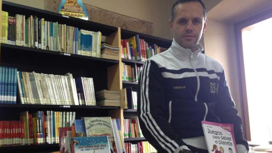 Iván Suárez Parades, en la biblioteca pública de Grado «Valentín Andrés», con un ejemplar de su nuevo libro.