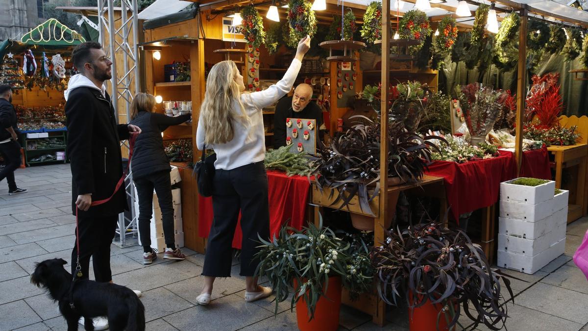 Una pareja observa ornamentación navideña vegetal en un puesto de la Fira de Santa Llúcia de Barcelona, el pasado día 25.