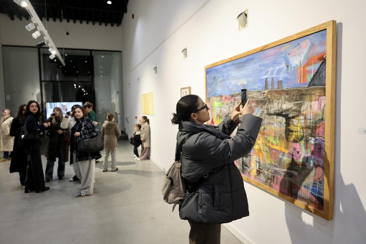 Una visitante registra un detalle de uno de los cuadros expuestos en el Salón de la Crítica