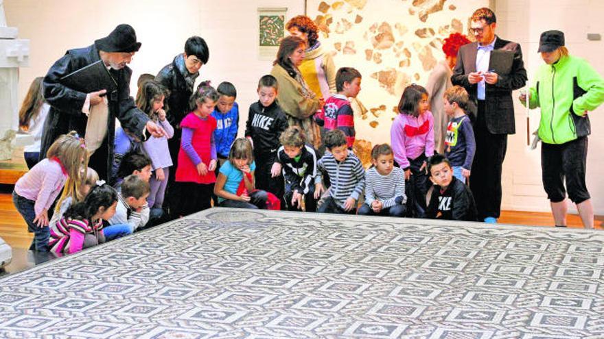 Los menores y los actores contemplan las estelas de uno de los mosaicos que exhibe el Museo de Zamora.