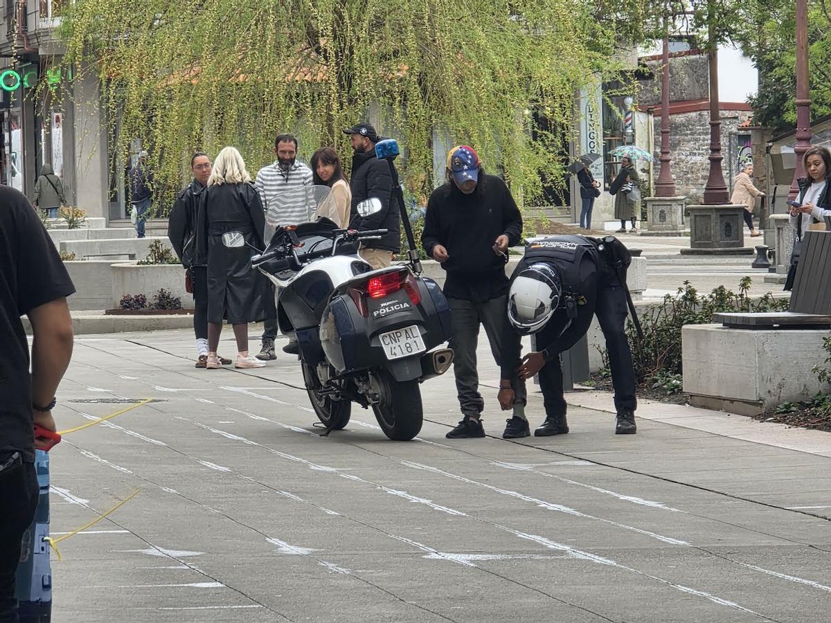 Un agente de la Policía Nacional cacheando a un transeúnte.