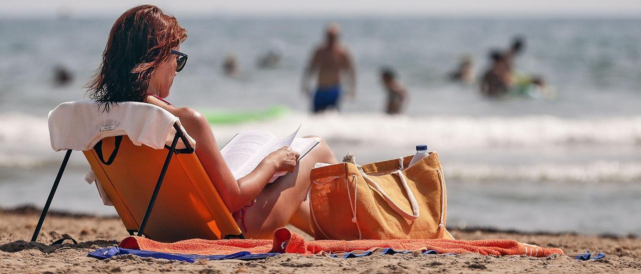 Una persona leyendo en la playa