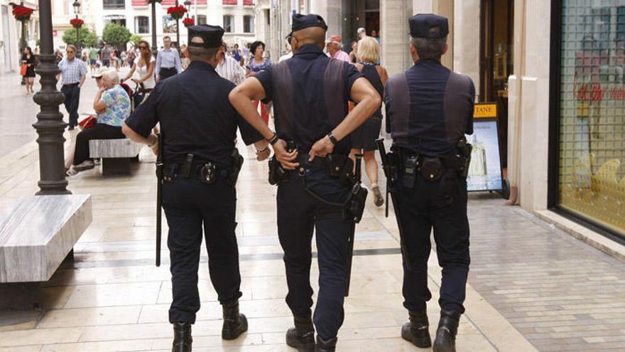 Tres agentes patrullan a pie por la calle Larios.