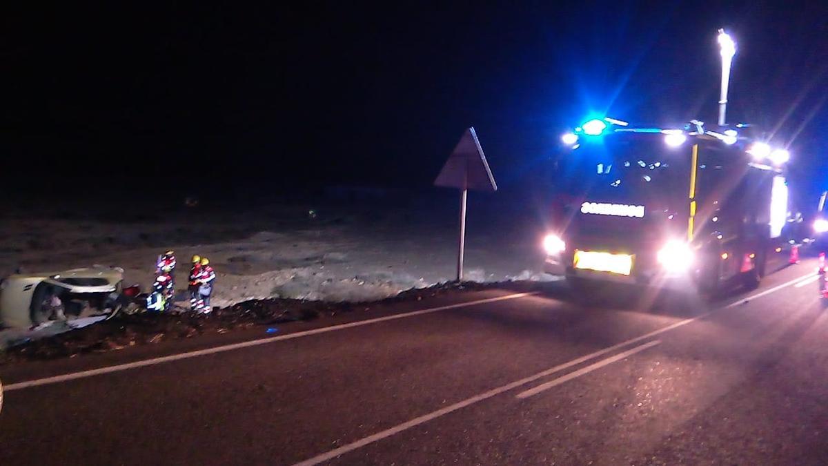 Los bomberos del Consorcio de Seguridad y Emergencias de Lanzarote junto al vehículo que volcó en la vía LZ- 701.