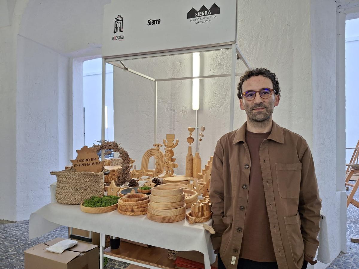 Juan Martín Acevedo junto al stand de diseño y artesanía en madera.