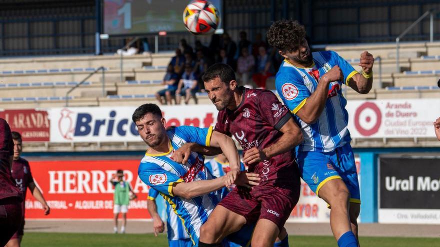 Claudio intenta ir de cabeza a un balón entre Ayoub y Jorge, de la Arandina. | Área 11