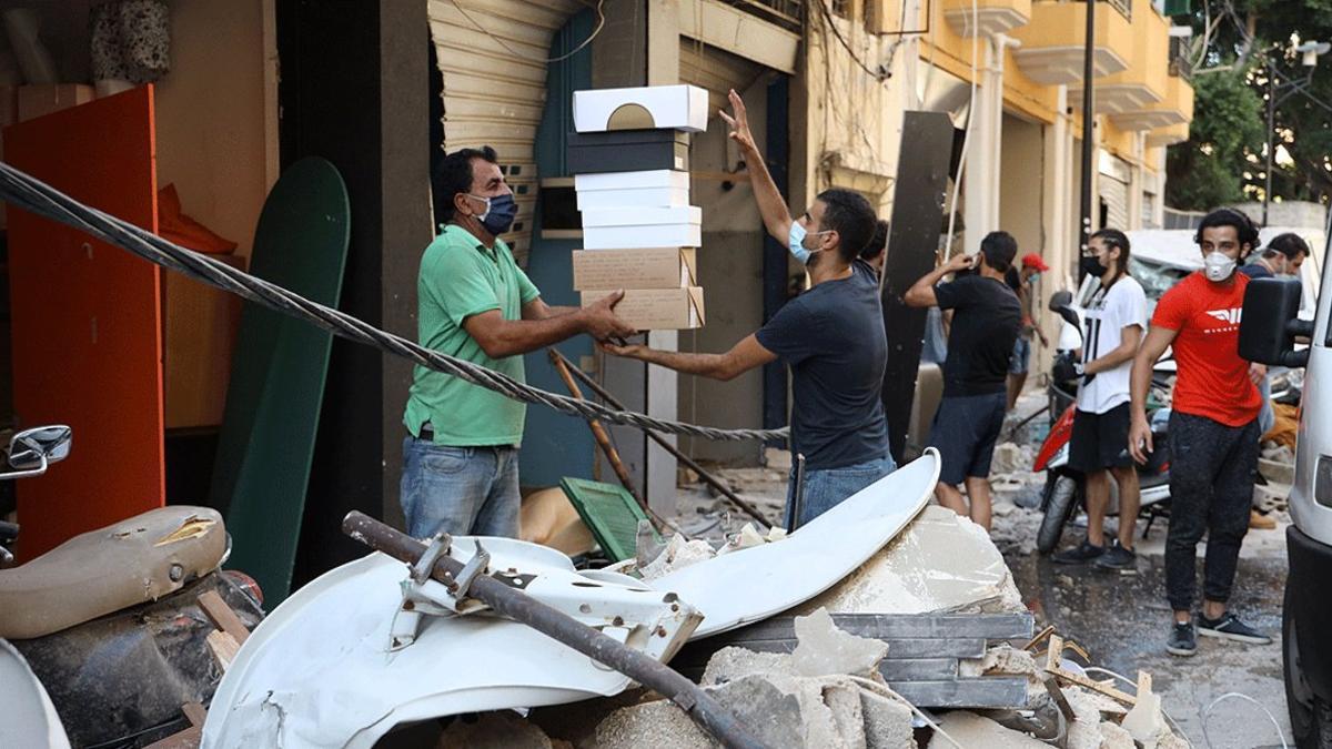 Varios comerciantes de Beirut tratan de recuperar parte de sus artículos entre las ruinas de la ciudad, este miércoles 5 de agosto