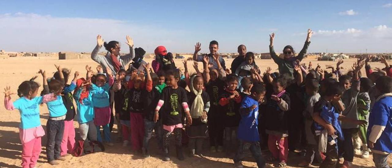 Imagen de un grupo de niños refugiados en pleno desierto de Argelia con las visitantes mallorquinas.