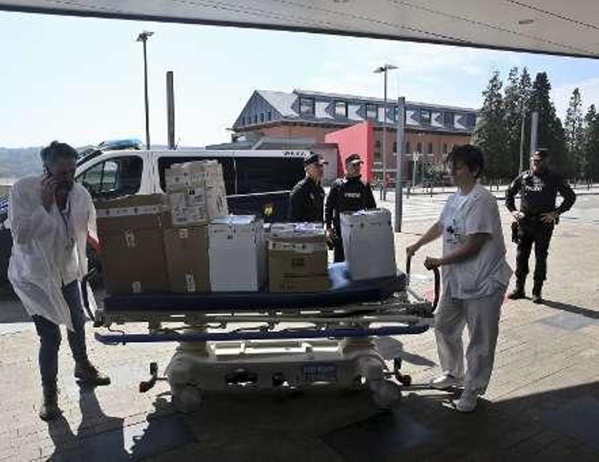 Dos sanitarios trasladan en una camilla el material cedido por el Cuerpo Nacional de Policía al HUCA.