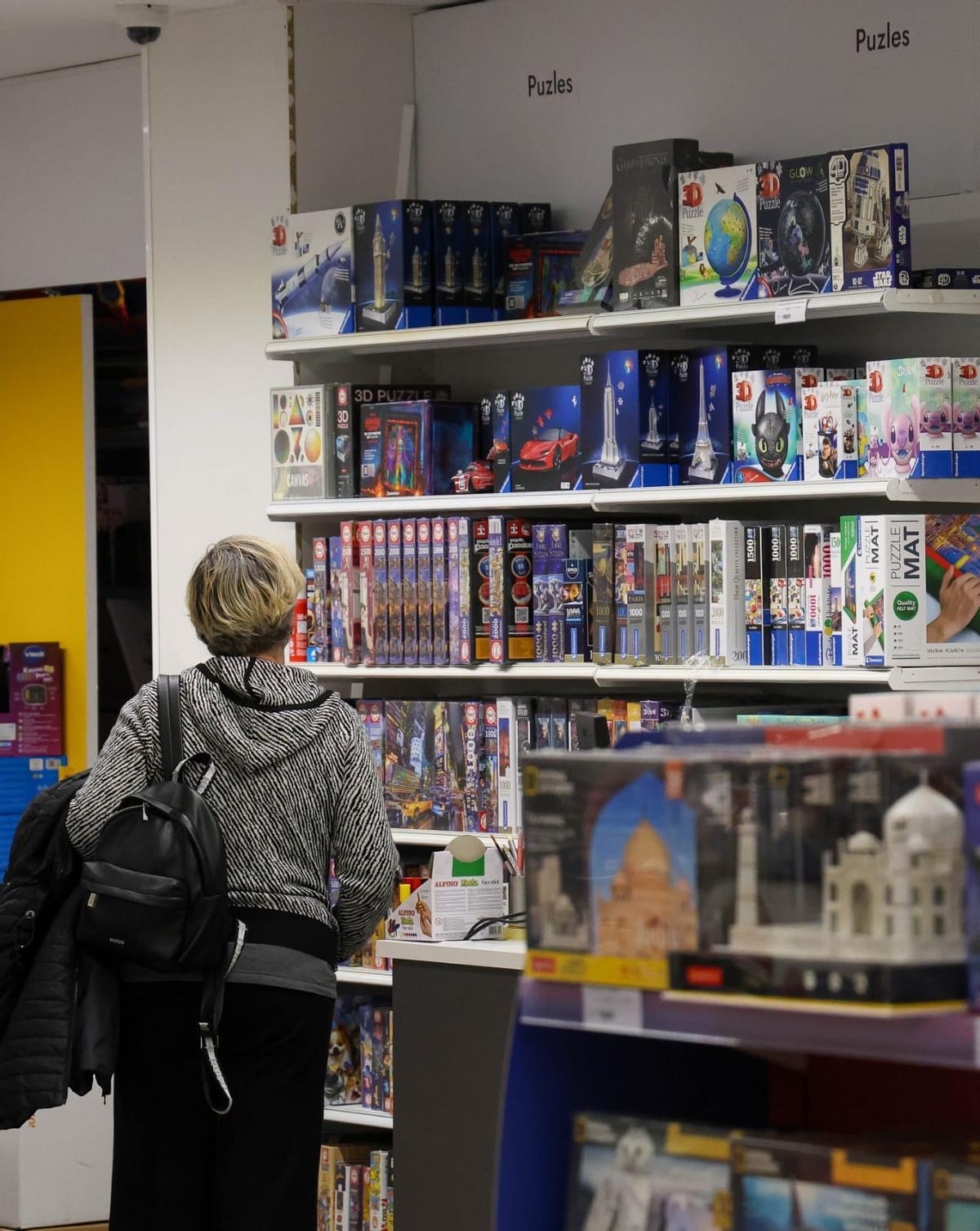 Una mujer observa los puzzles de una juguetería en València