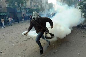 Un manifestant egipci retira una bomba de gas lacrimogen durant la protesta contra les forces de seguretat al Caire (Egipte).