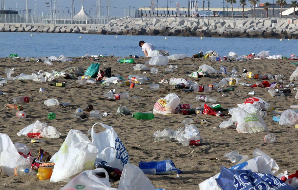 Los operarios de los servicios de limpieza trabajan para dejar la playa en óptimas condiciones tras una larga noche de fiesta en la arena