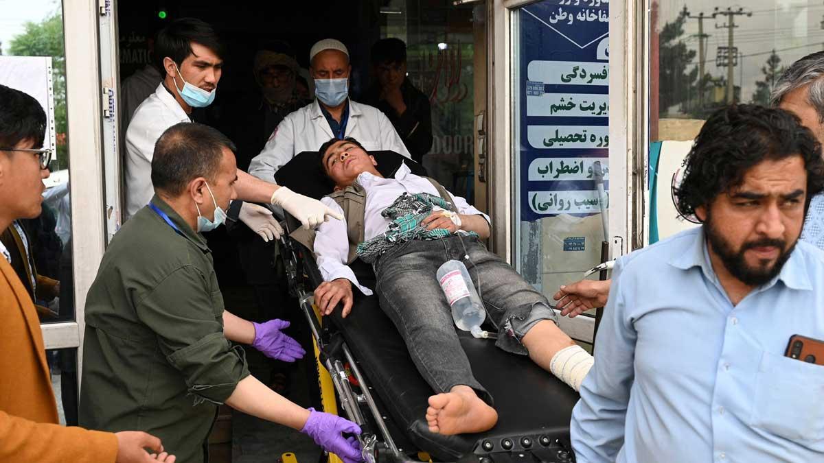 Personal médico traslada a un joven herido tras el atentado contra una escuela en Kabul