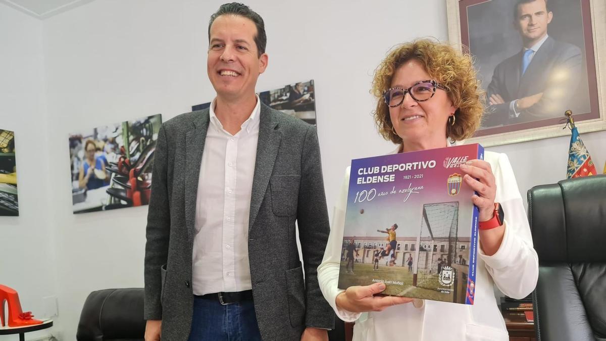 La consellera con el alcalde Rubén Alfaro mostrando el libro del centenario del Deportivo Eldense.