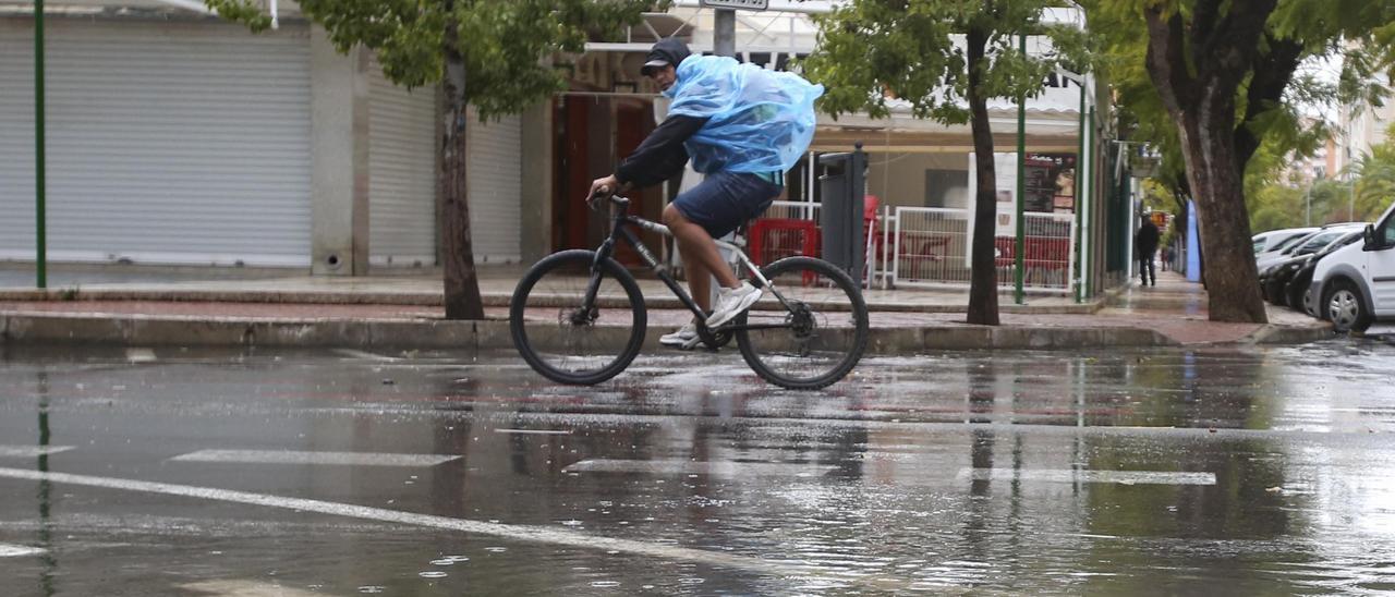 Un ciclista, en un día de lluvia, en Playa de San Juan