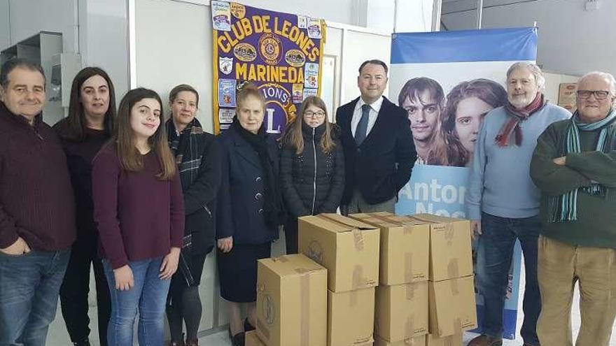 Miembros del Club de Leones entregan los alimentos.