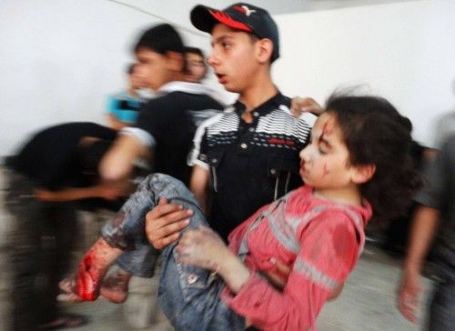 An injured girl is carried to a hospital after what activists said was an airstrike by forces loyal to Syria's President Bashar al-Assad at the Damascus suburb of Saqba
