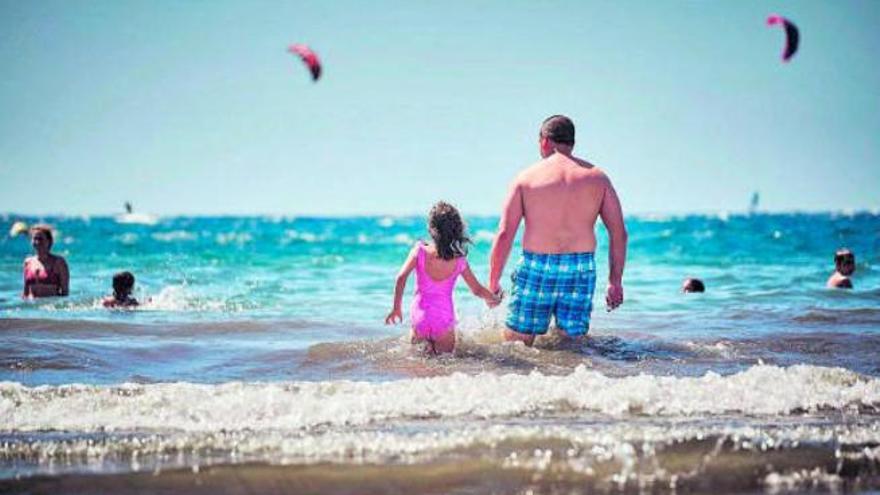 Un padre y una hija se adentran en una playa del Archipiélago.
