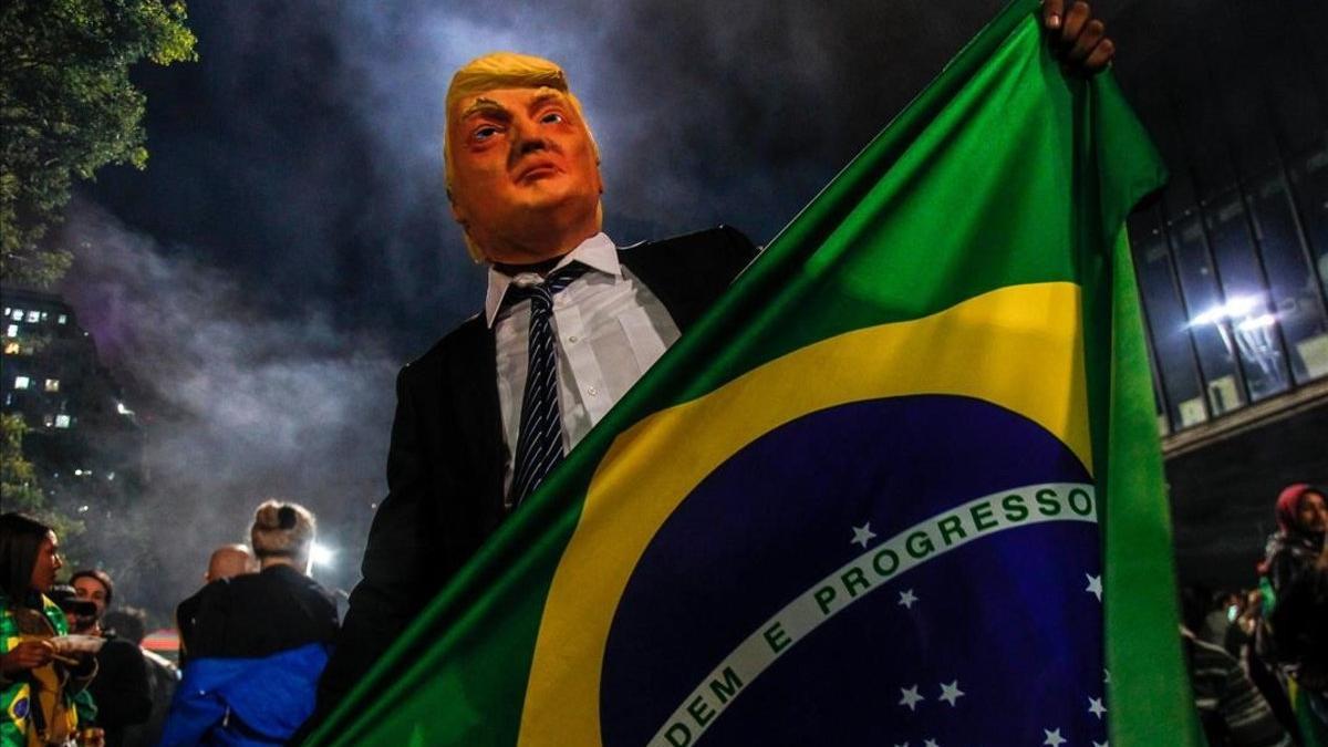 Un simpatizante de Bolsonaro luce una máscara de Trump durante las celebraciones por la victoria del dirigente brasileño en Sao Paulo.