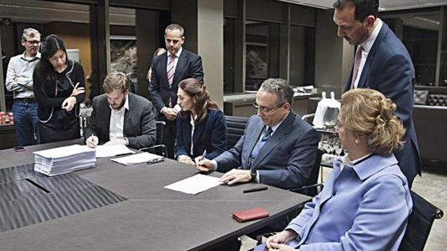 Antonio Asensio, presidente de Grupo Zeta (izqda.), y Javier Moll, presidente de Prensa Ibérica (dcha.), en el momento de la firma de la operación. Arantza Sarasola, vicepresidenta de Prensa Ibérica, a la izquierda de Javier Moll.