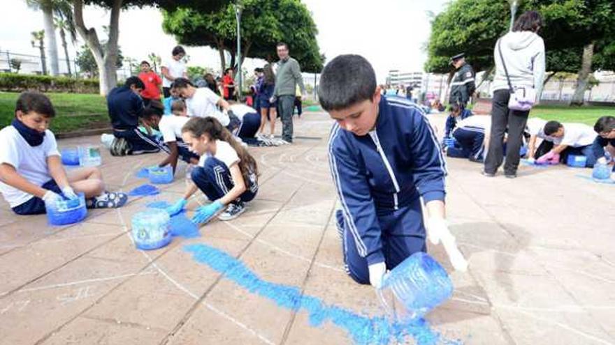 Un grupo de escolares participantes echan sal para hacer su alfombra en los jardines del Castillo de La Luz, ayer. | yaiza socorro