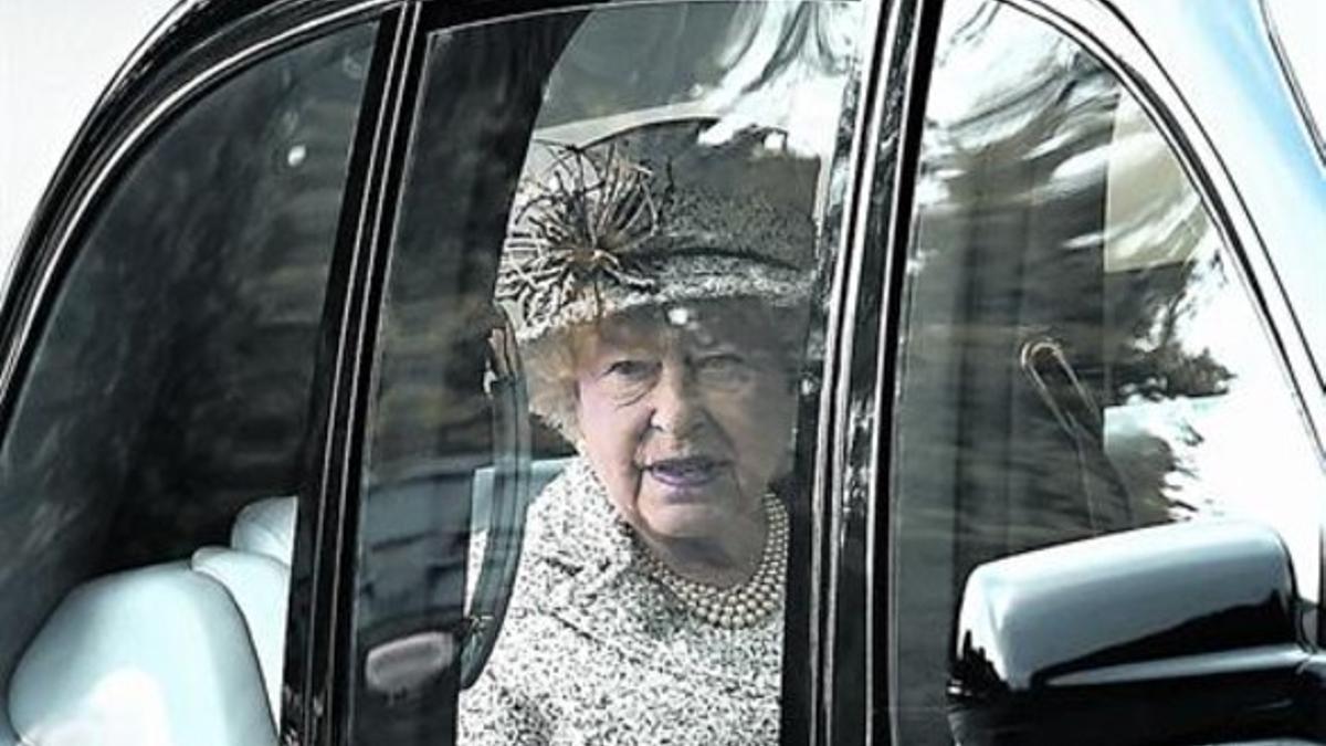 La reina Isabel mira desde su coche al llegar a la localidad escocesa de Crathie para asistir a una misa.