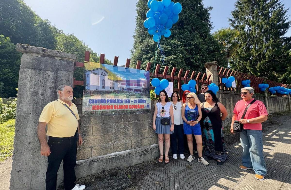 Miembros de la asociación Tea Nalón y Musi Pedro Duro, con Sandra Blanco, segunda por la izquierda, ante el colegio La Salle de Ciaño con la pancarta reivindicativa. | D. O.