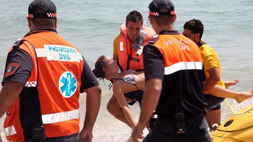 Una de las víctimas simuladas es trasladada a la orilla por los servicios de salvamento.