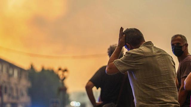 Diverses persones observen el foc durant les tasques d’extinció a La Adrada (Àvila). | CÉSAR VALLEJO RODRÍGUEZ / EUROPA PRESS