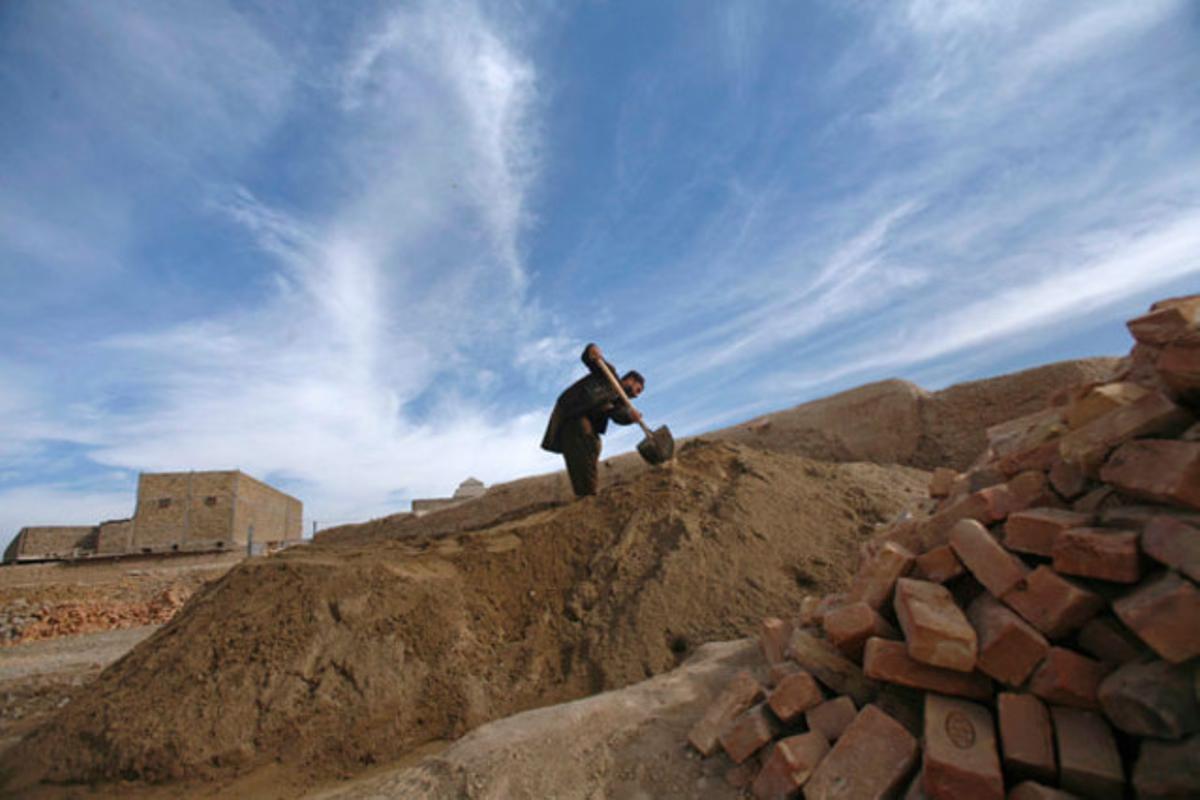 Un venedor de material de construcció amuntega sorra amb una pala a Quetta (Pakistan).