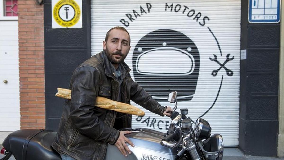 El director de Felnuti, Álex Comajuan, ante el taller de motos del que también es socio.