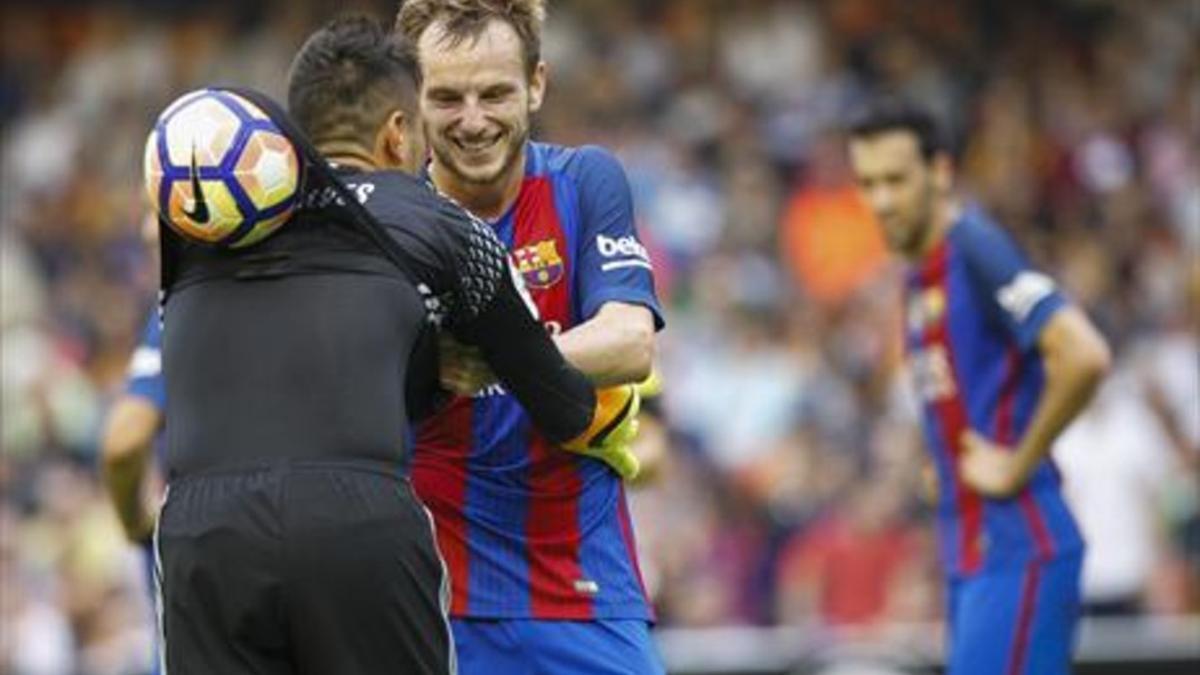 Rakitic se ríe del gesto de Alves, que esconde el balón en la espalda.