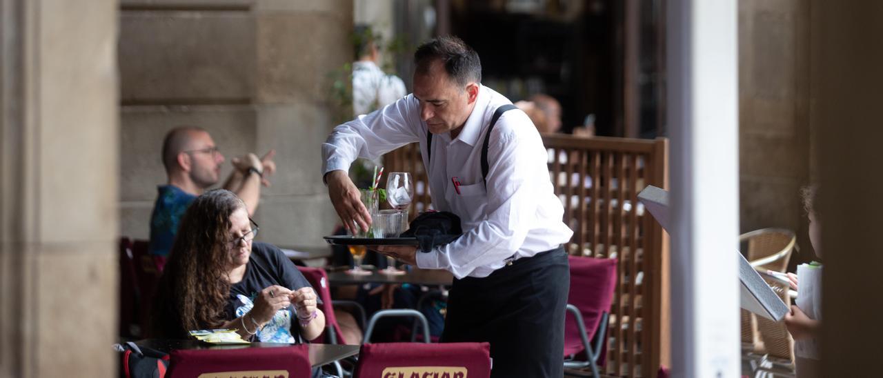 Camarero recogiendo mesas en un restaurante.