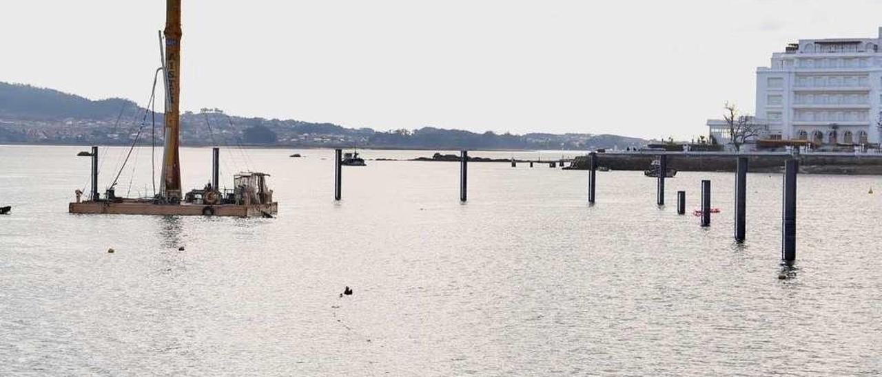 Pilotes instalados para el nuevo puerto deportivo, con el Gran Hotel La Toja, al fondo. // Muñiz