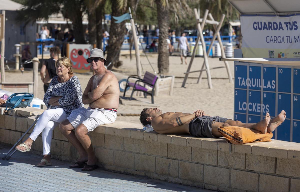 Varias personas sin camiseta junto a la playa del Postiguet, esta semana